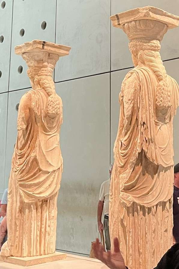 Two tan antiquities in the Acropolis Museum in Athens, Greece